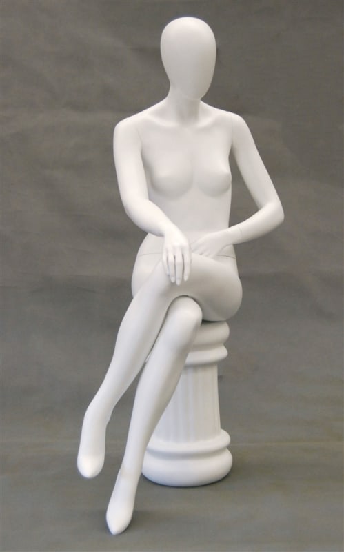 Seated matte white female fiberglass mannequin with left leg crossed sitting on a white stool base.