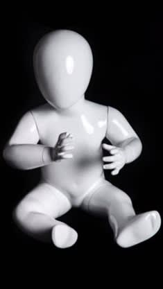 Sitting glossy white toddler mannequin with abstract egghead made of fiberglass for retail store display.