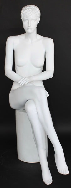 Seated white female mannequin with molded hair, matte fiberglass finish, and crossed-leg pose for apparel displays