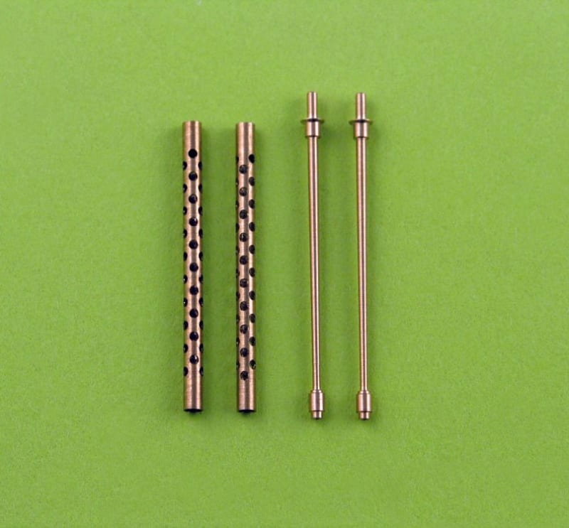 Photo of actual scale model brass aircraft machine gun barrels on green felt.