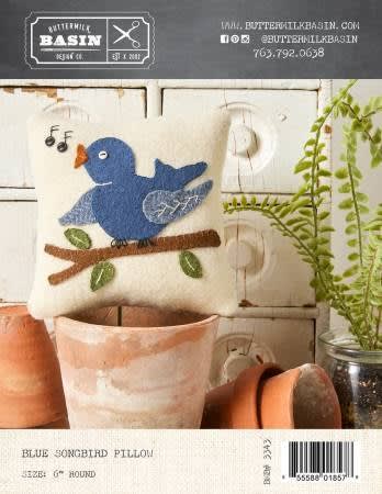 BLUEBIRD SONG WOOL PILLOW PATTERN from Buttermilk Basinshows a pretty CREAM PILLLOW WITH A SINGING BLUEBIRD.