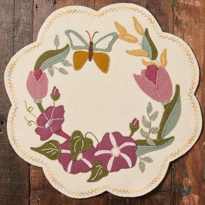 MORNING GLORIES & BUTTERFLY WOOL MAT PATTERN from Buttermilk Basin from Buttermilk Basin shows a cream mat with blossoms of morning glories and butterflies.