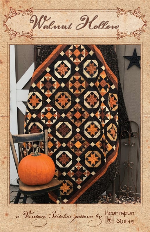 Walnut Hollow Quilt Pattern by Heartspun Quilts shows a traditional quilt in many colors on a dark background.