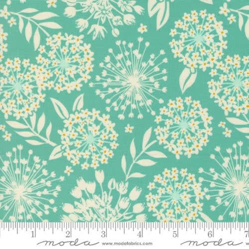 Tango Simpatico Sea Blue 27332 -23 shows a stylized floral pouf with burst of flowers and leaves in-between in soft sage green.
