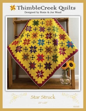 Star Struck Quilt Pattern by Thimble Creek shows a bright quilt featuring star blocks in many colors on a bright cheddar ground.