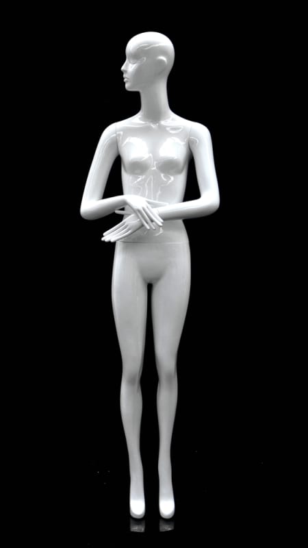 Abstract female mannequin in glossy white fiberglass with arms crossed in front and a round glass base.