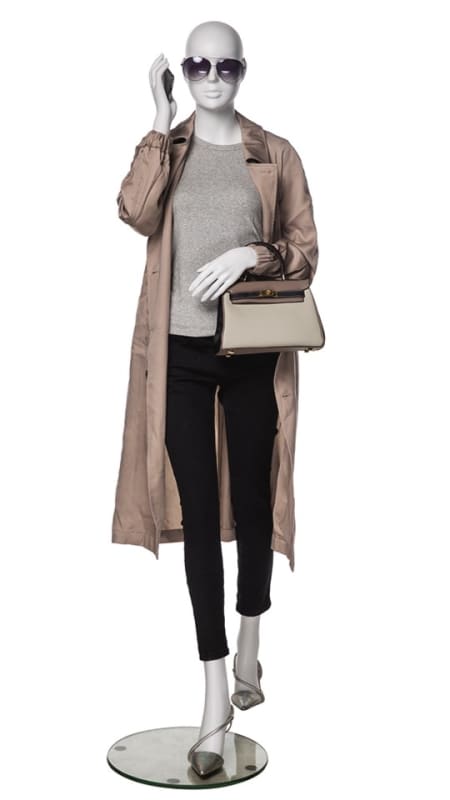 Matte white fiberglass female mannequin in a walking pose holding a cell phone on a stable metal base for lifestyle retail displays.