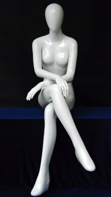 Glossy white female seated egghead mannequin made of fiberglass in a natural sitting pose with no base.