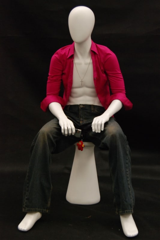 Egghead male mannequin seated with arms on knee for modern retail clothing and fashion display