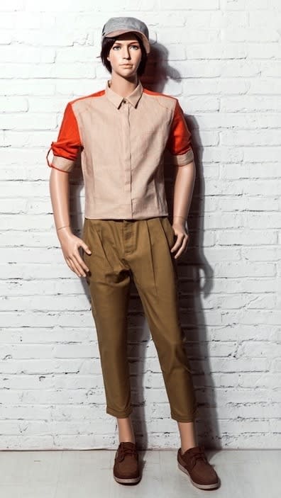Realistic male teenage fiberglass mannequin on a square glass base with calf support for retail clothing displays.