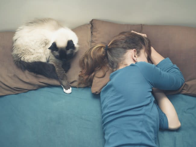 Woman sleeping in bed with cat