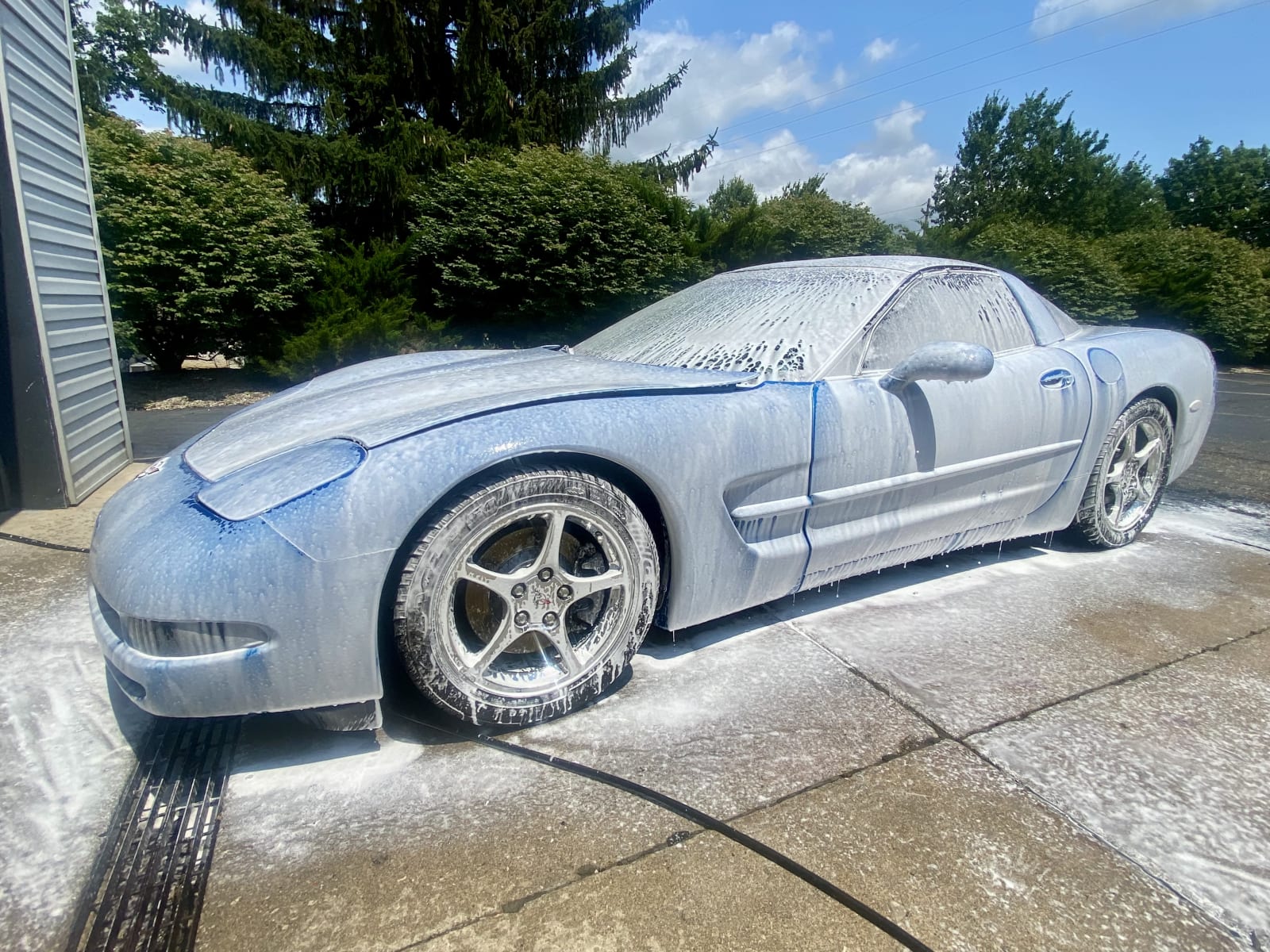 Blue Corvette mid-wash during premium auto detailing service
