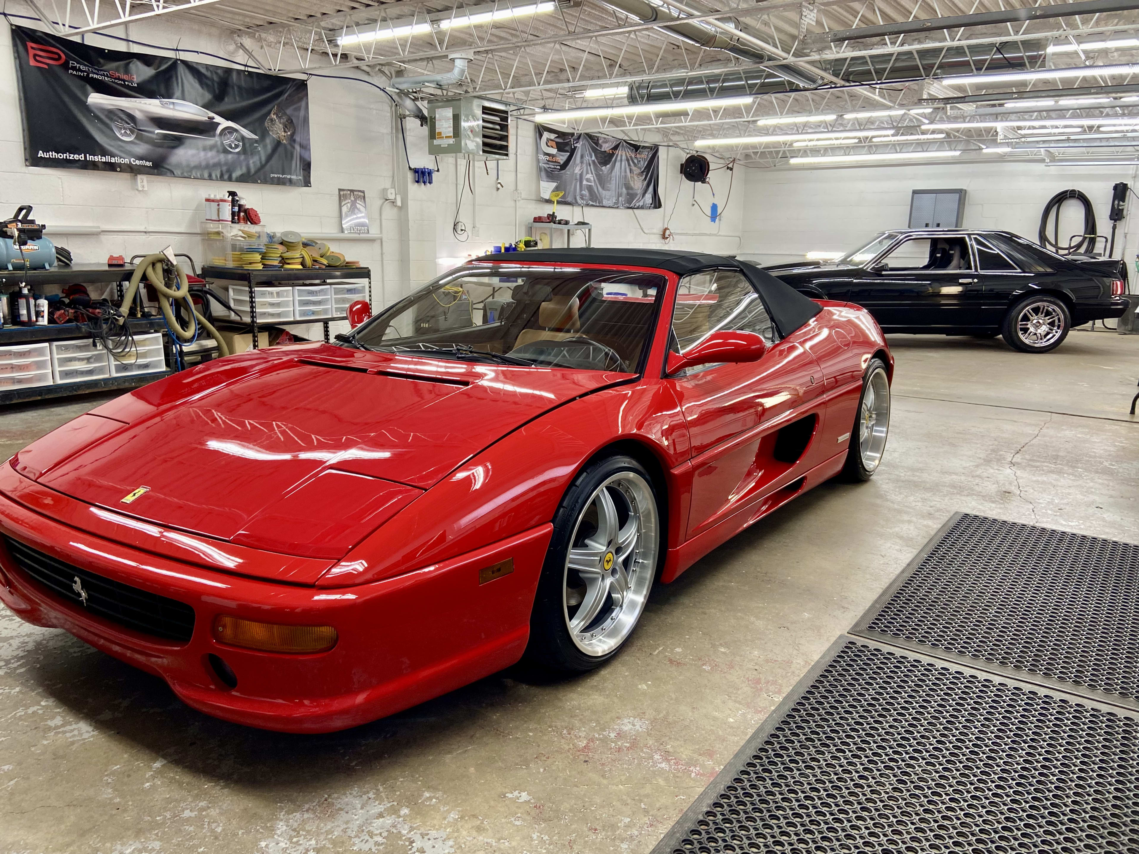 Red Ferrari and Mustang in JayClean garage after exterior detailing