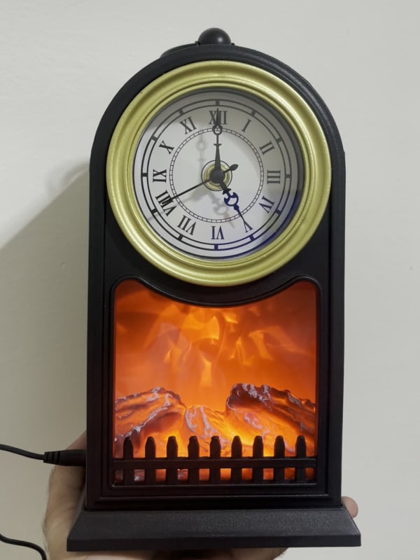 Horloge cheminée LED vintage noire et dorée, effet flamme allumé, vue de face