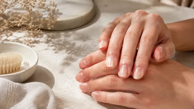 Mains posées montrant des ongles naturels avec de fines stries verticales
