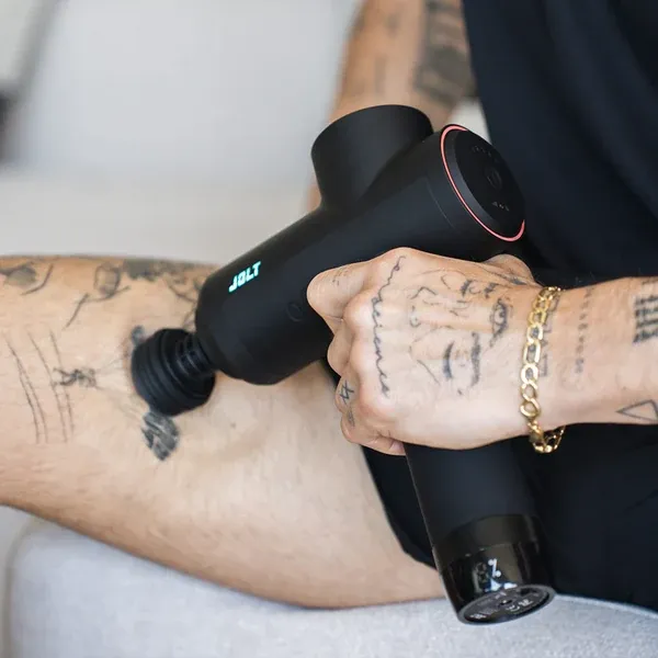 Le pistolet de massage Jolt Bolt+ utilisé sur les quadriceps