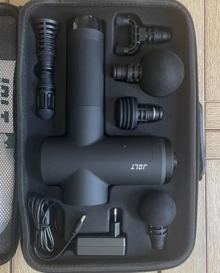 Le coffret du Jolt Bolt+ ouvert avec le pistolet, les six têtes de massage, le chargeur et les livrets