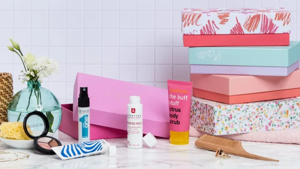Boîtes Blissim empilées entourées de produits de beauté en format découverte