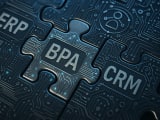 Circuit-patterned puzzle pieces representing ERP and CRM systems fitting perfectly together through a central BPA connection piece, symbolizing seamless business system integration.