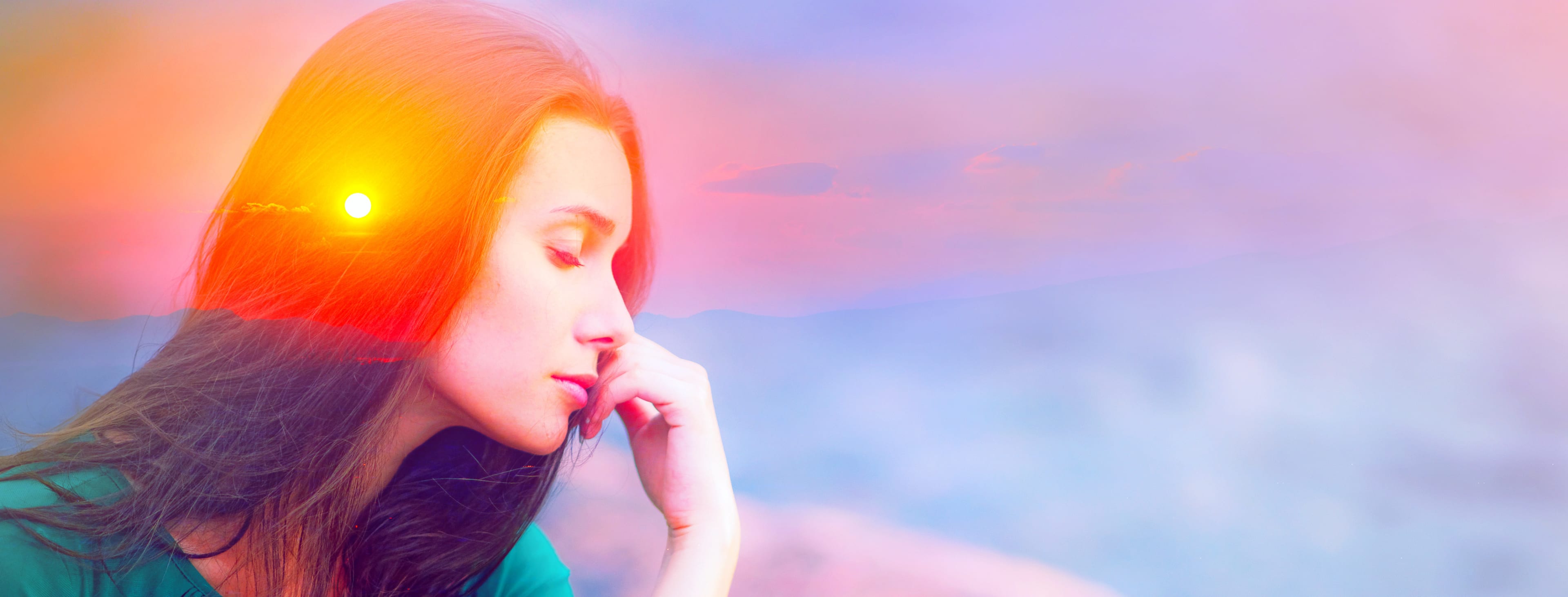 Double exposure abstract of sunset over a thoughtful young woman, closed eyes, chin on hand.