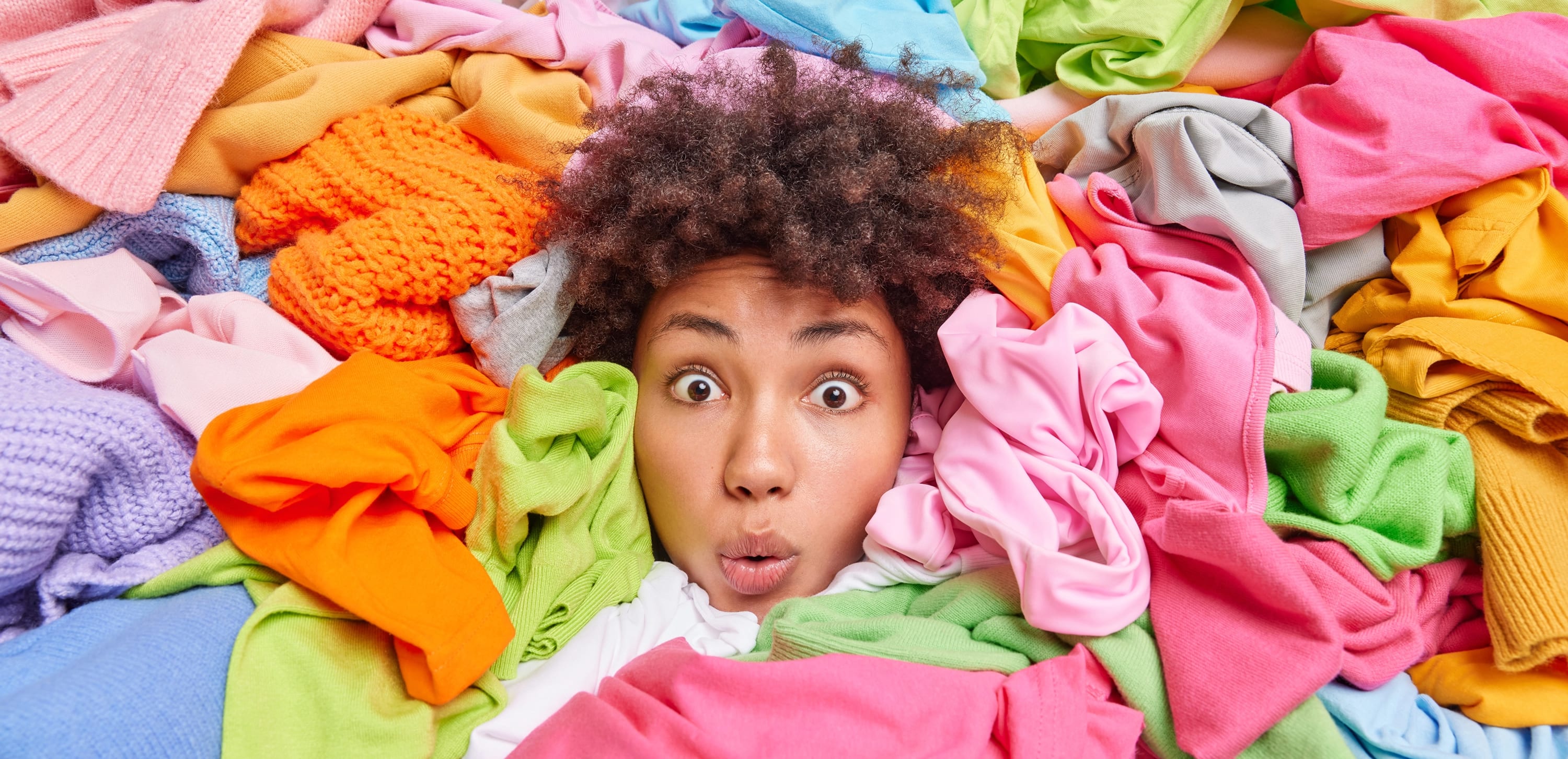 Woman surrounded by colorful clothes