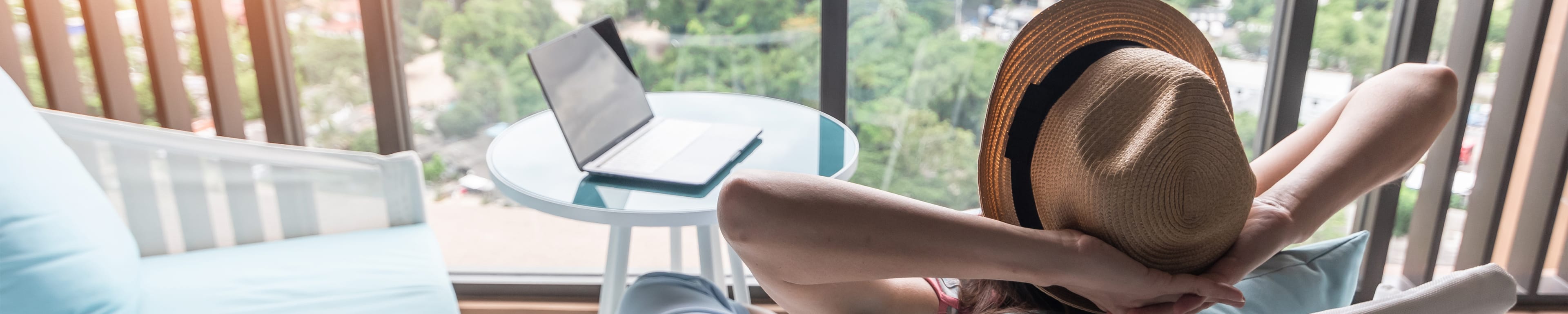 Woman relaxing on a balcony with laptop in background