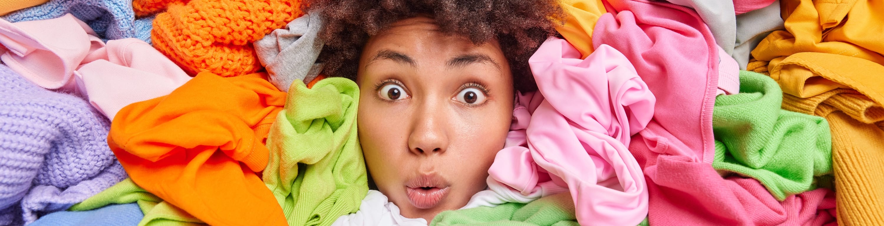 Woman surrounded by colorful clothes