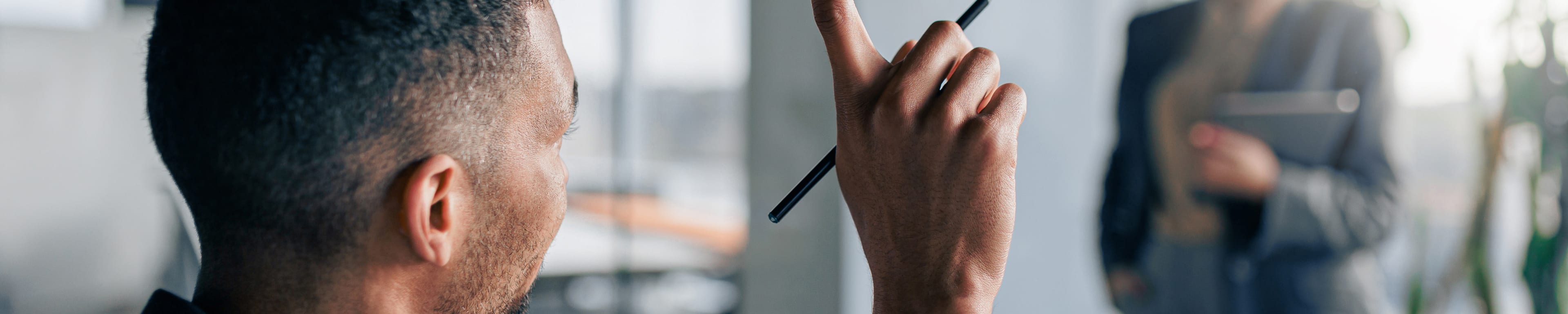 Man raises hand to ask question in business setting
