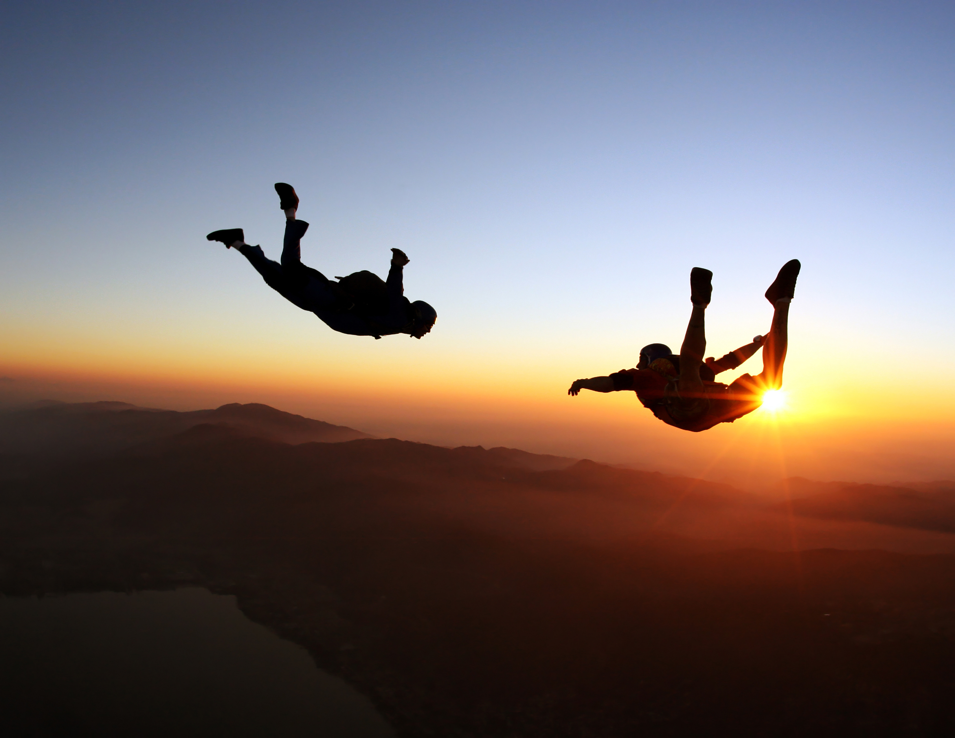 Two people skydiving in freefall at sunset {768x432}