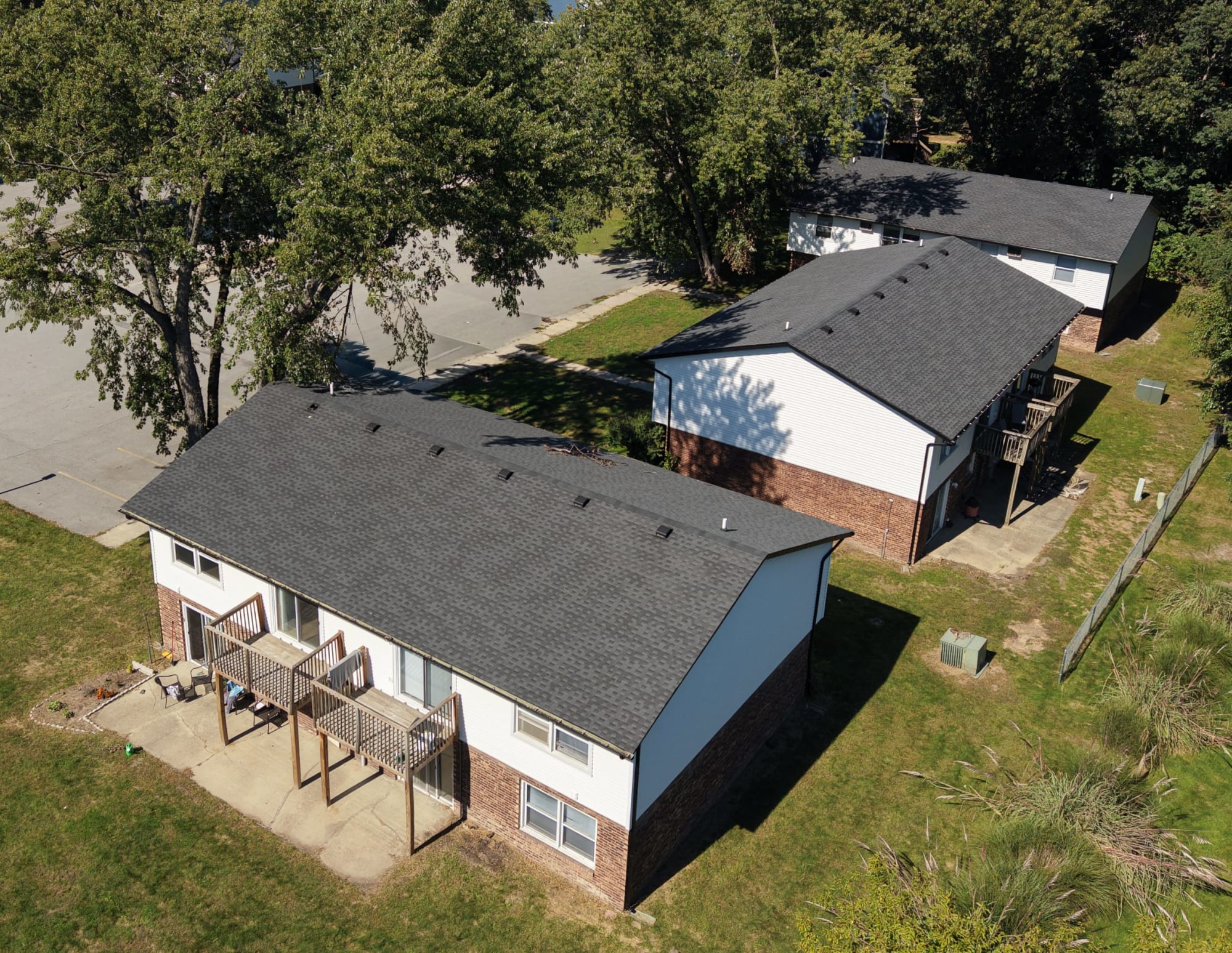 Aerial of two-story buildings with new roofs and rear decks