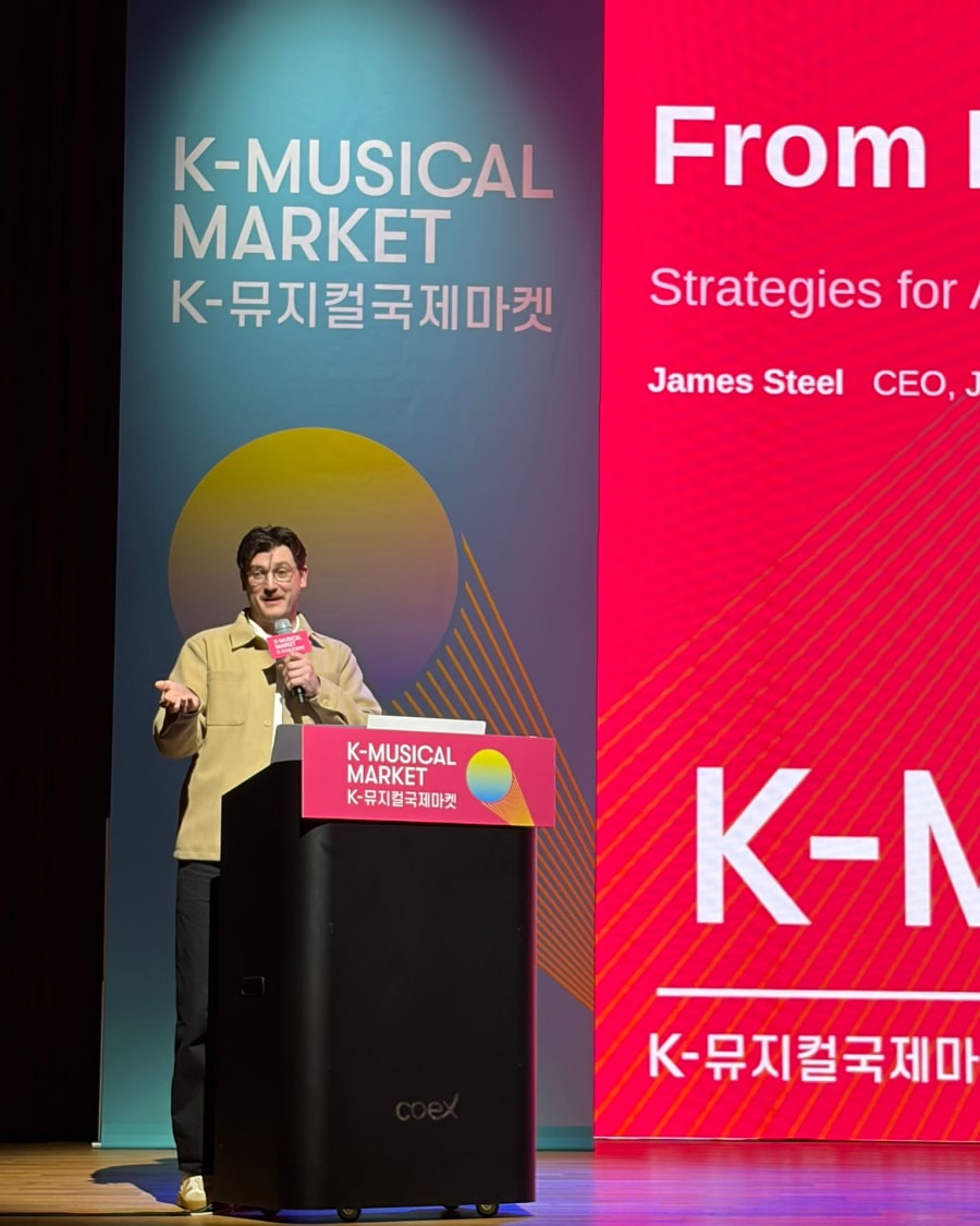 James Steel presenting at the 2026 K-Musical International Market, COEX Seoul, with his name on the forum screen