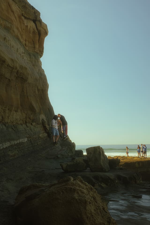 Beach people climbing rocks