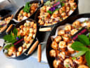 Platters of gourmet gluten-free shrimp and crispy noodle appetizers with microgreens, ready for catering.