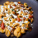 Orecchiette pasta dish with mushrooms, roasted tomatoes, fresh herbs, and crumbled feta cheese, representing Danny's Pasta.