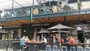 Vibrant multi-level dining precinct at Riverside Market with various restaurants and people enjoying prepared food outdoors.