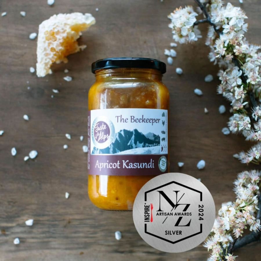Jar of Taste of the Alps Apricot Kasundi, handcrafted in Central Otago, with honeycomb, blossoms, and NZ Artisan Awards silver medal.
