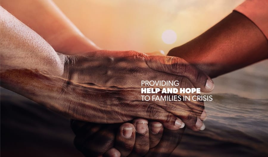 Two people holding hands with a warm sunset and ocean overlay. Text reads 'Providing help and hope to families in crisis'.
