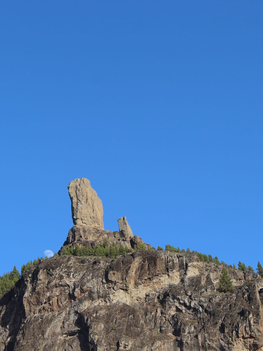 Roque Nublo på åsen ovanför tallskogen, med en mindre spira bredvid
