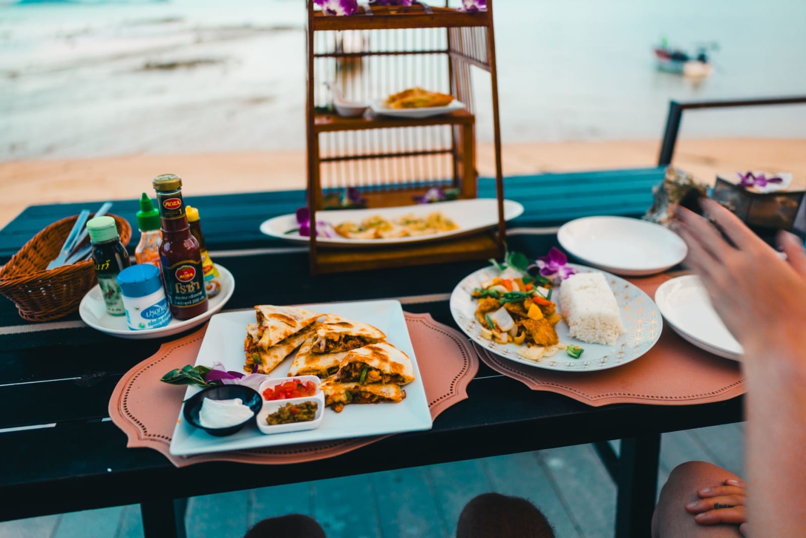 A Thai meal laid out on a table beside the water