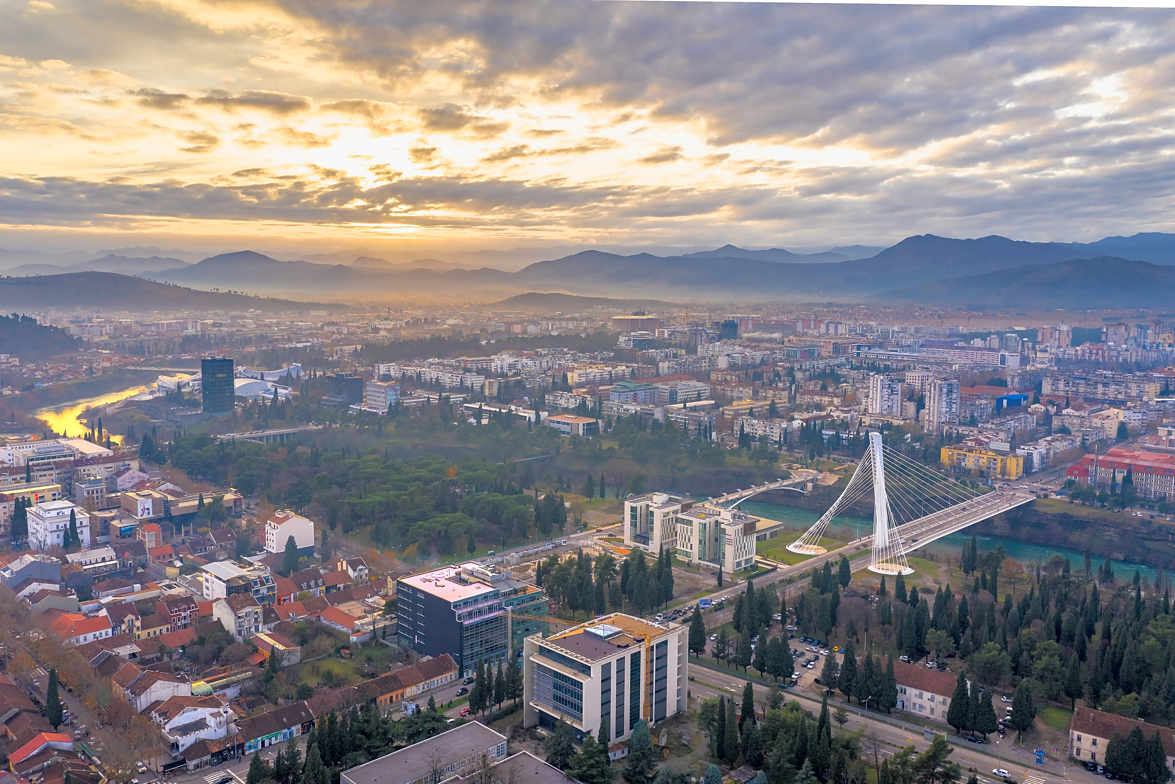 Podgorica skyline at sunset over the Morača river and Millennium Bridge, Montenegro