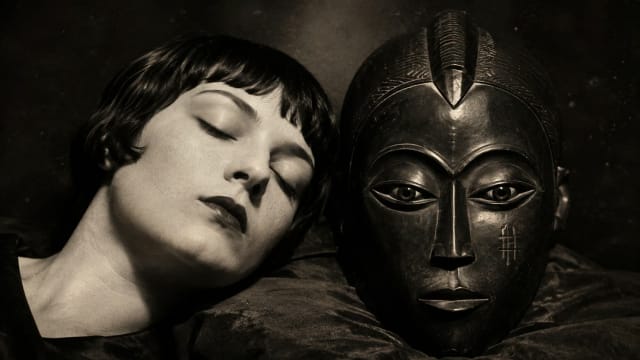 Kiki de Montparnasse with an African mask in a dramatic black-and-white portrait exploring perception, surrealism and human consciousness.