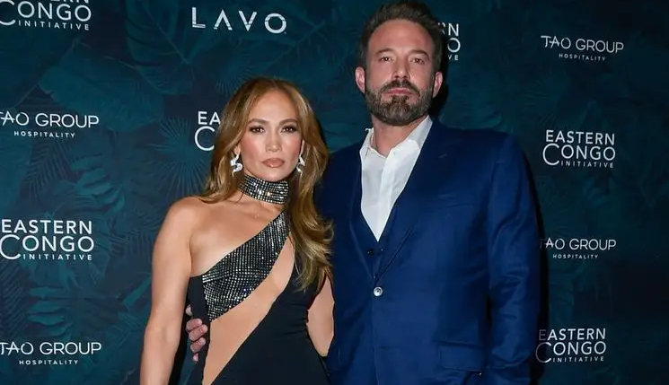 Jennifer Lopez in an asymmetric black sequined gown and Ben Affleck in a navy three-piece suit, posing together at a step-and-repeat event for the Eastern Congo Initiative.