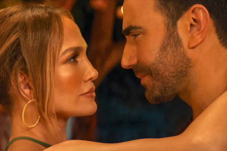 Jennifer Lopez gazing into Brett Goldstein eyes in a still from their film Office Romance