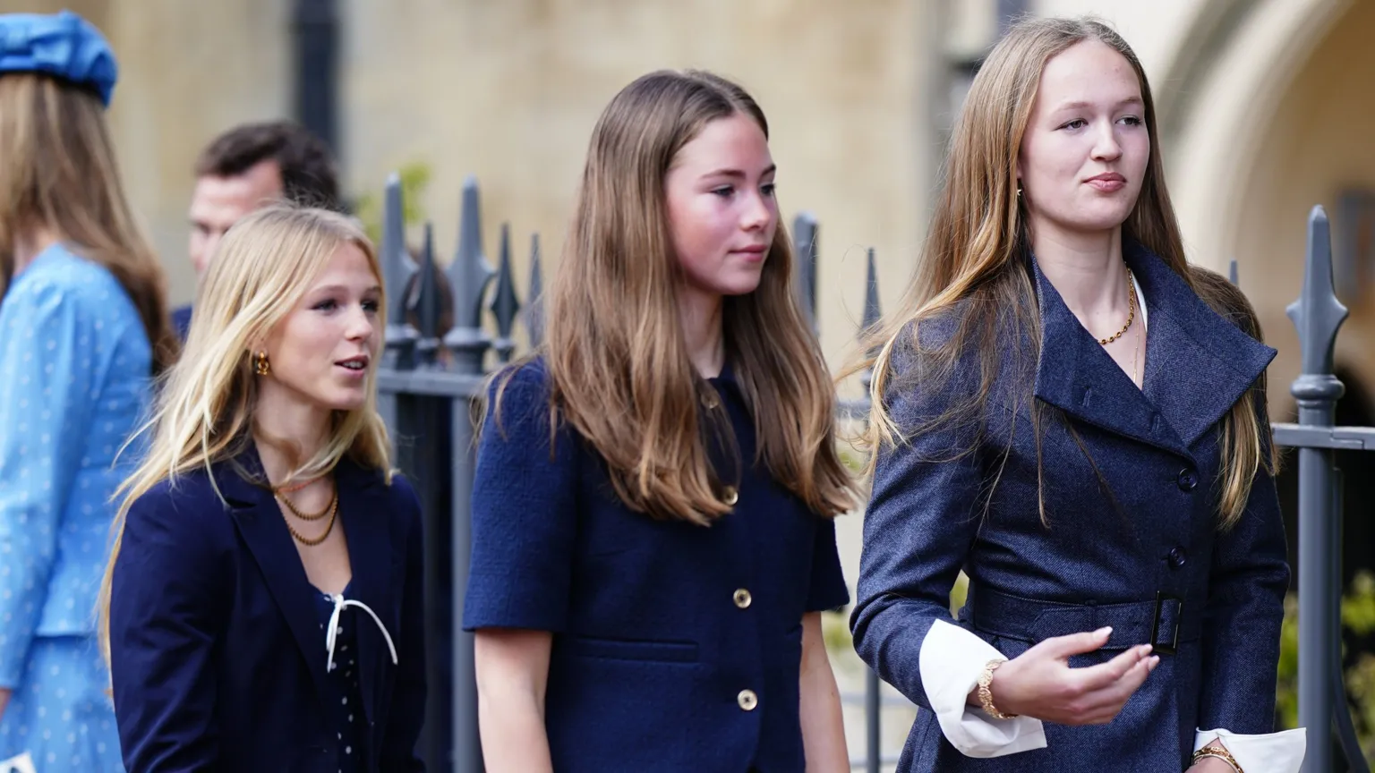 Peter Phillips and Harriet Sperling's teenage daughters in coordinating navy blue outfits walking outdoors near wedding venue