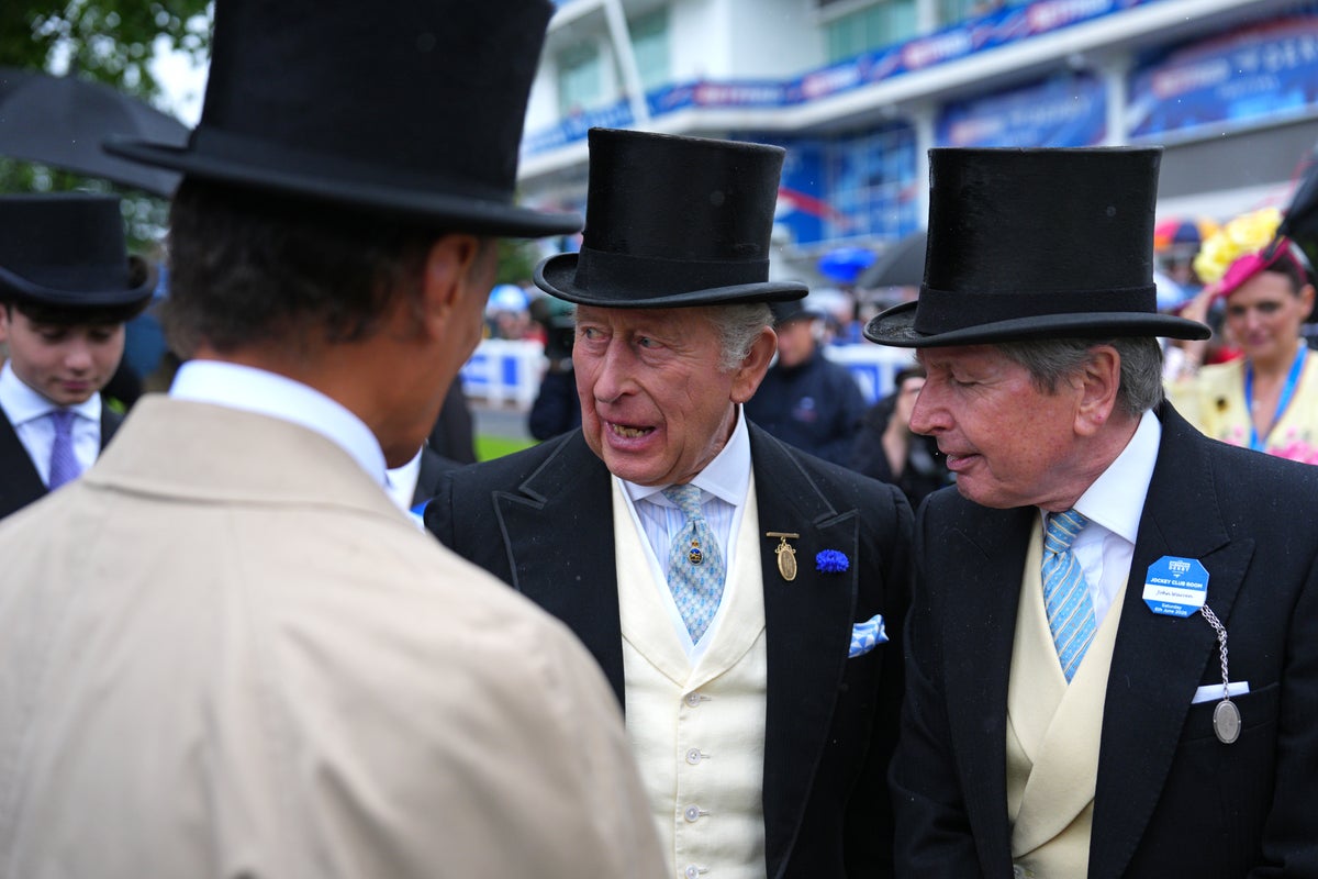 King Charles in morning dress and top hat, chatting with guests at Royal Ascot.