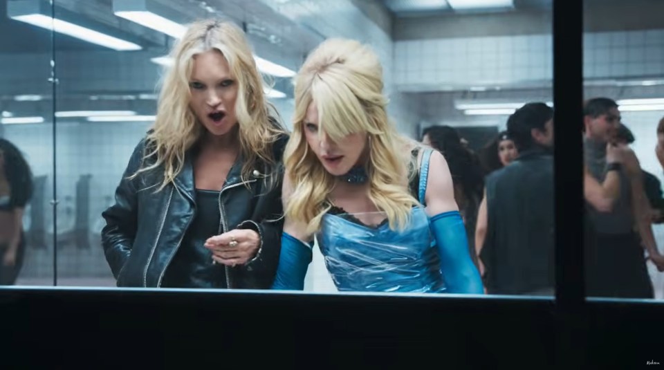 Kate Moss and Madonna; one wearing a black leather jacket, the other in a blue dress in a still from her Confessions II – The Film music video