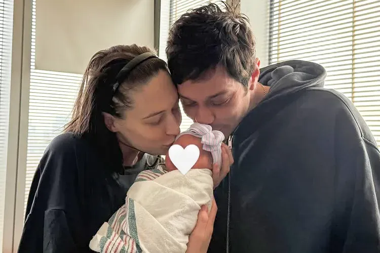 Pete Davidson and Elsie Hewitt kissing their newborn baby.