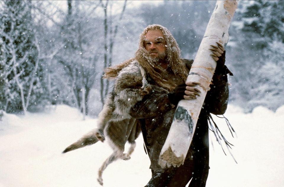 Tyler Mane as Beast carrying a tree trunk in a snowy forest scene from an X-Men film.