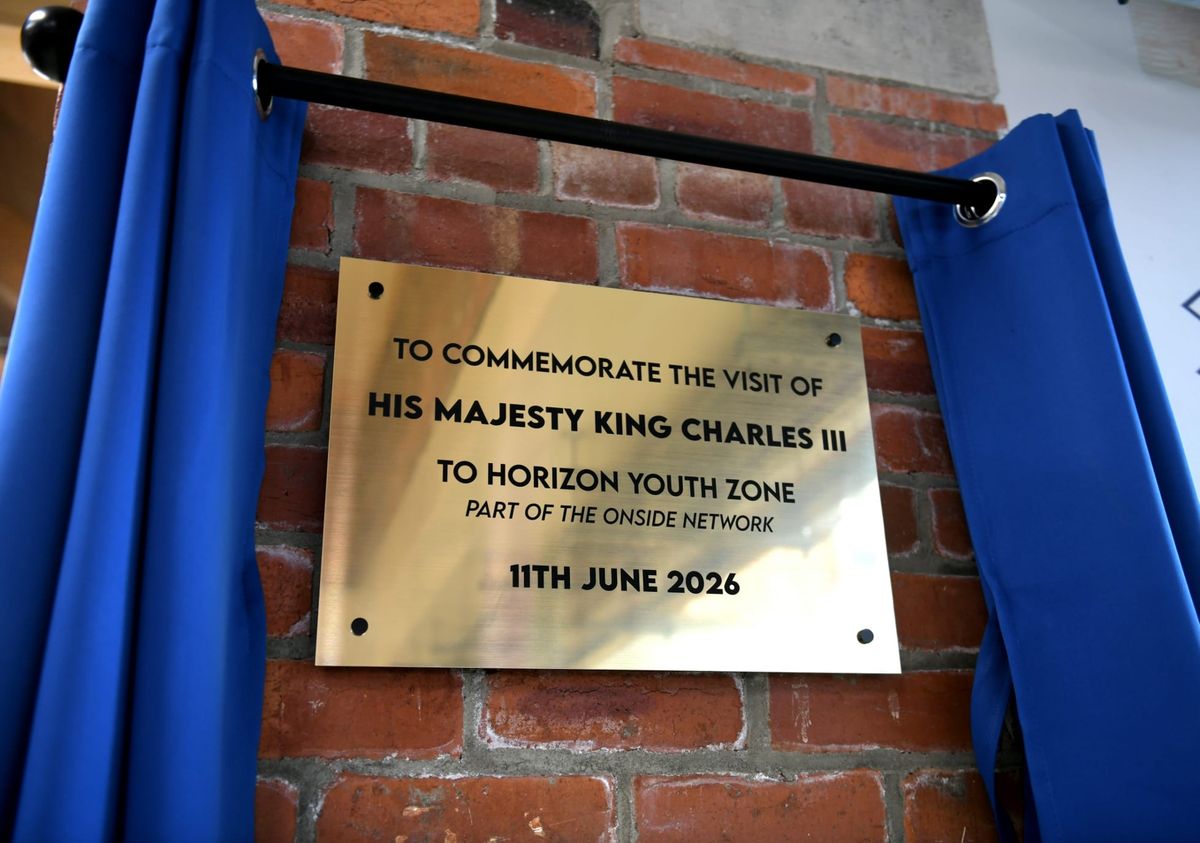 A brass commemorative plaque on a brick wall marking King Charles III's visit to Horizon Youth Zone on June 11, 2026.