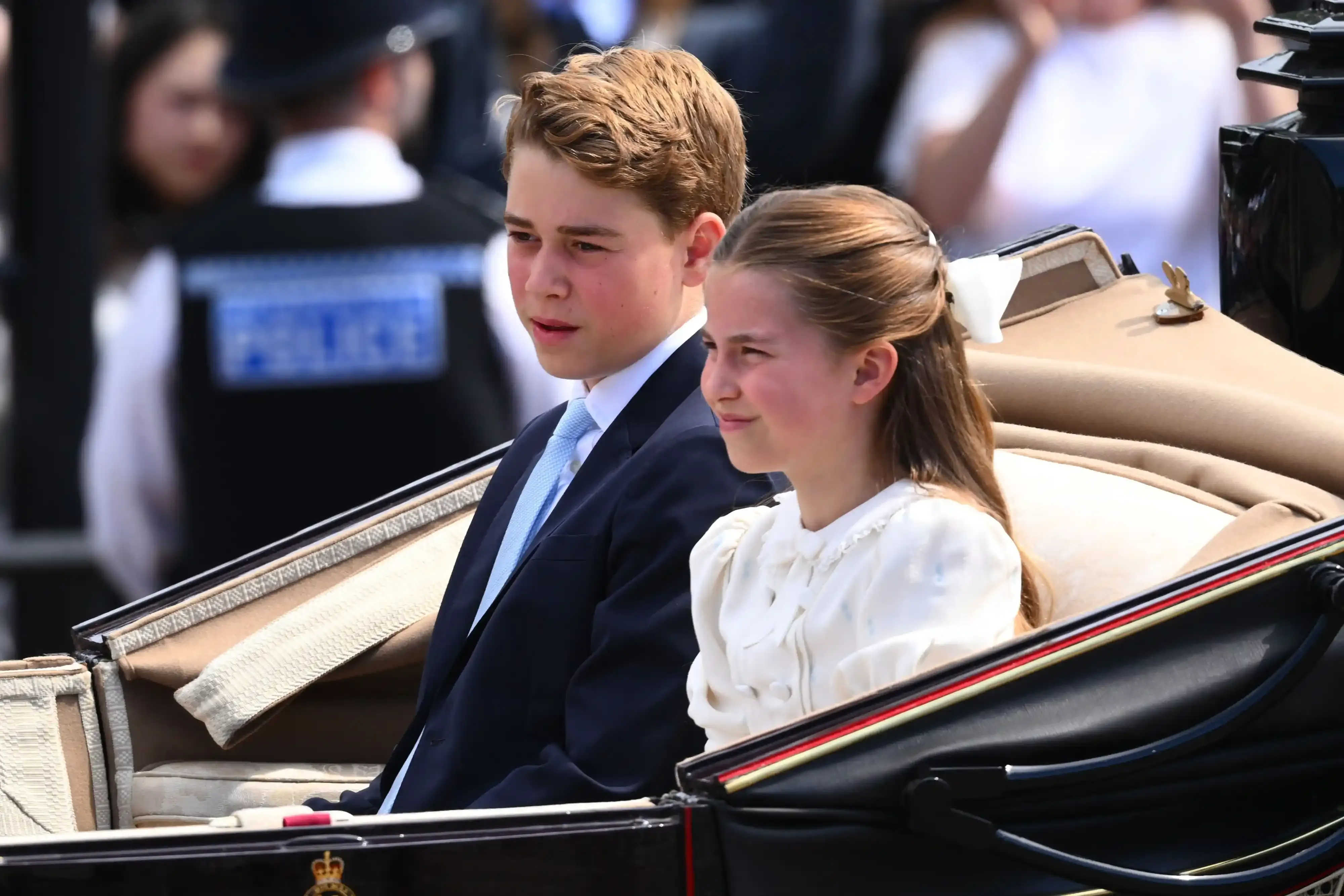 Prince George and Princess Charlotte riding in an open carriage at Trooping the Colour.